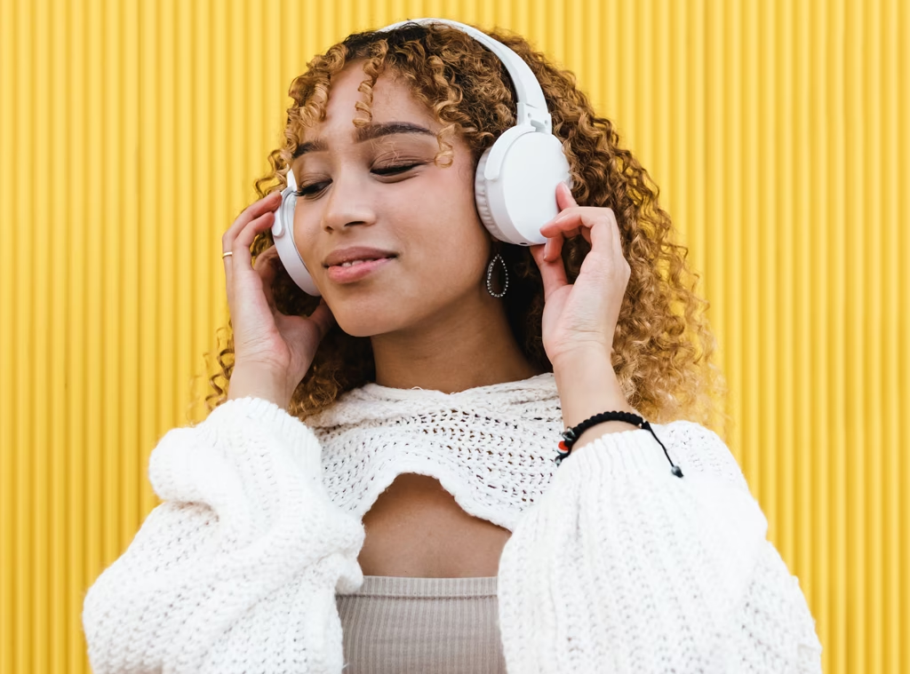 young lady listening to music on headphones and smiling